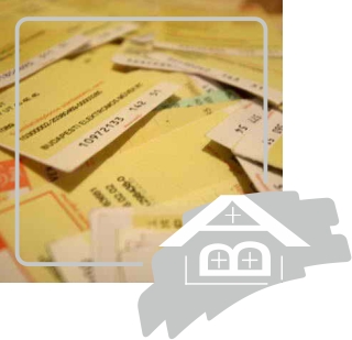 Overlapping pale yellow printed papers fill the image, with small lines of dark text and numbers that are too soft to read. A thin white rounded rectangle overlays the upper and left portions. A large pale gray-and-white house-shaped graphic overlaps the lower-right corner.