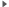 A small gray triangular arrow points to the right on a white background. Its edges are pixelated and a few shades of gray are visible. No text or other objects appear.