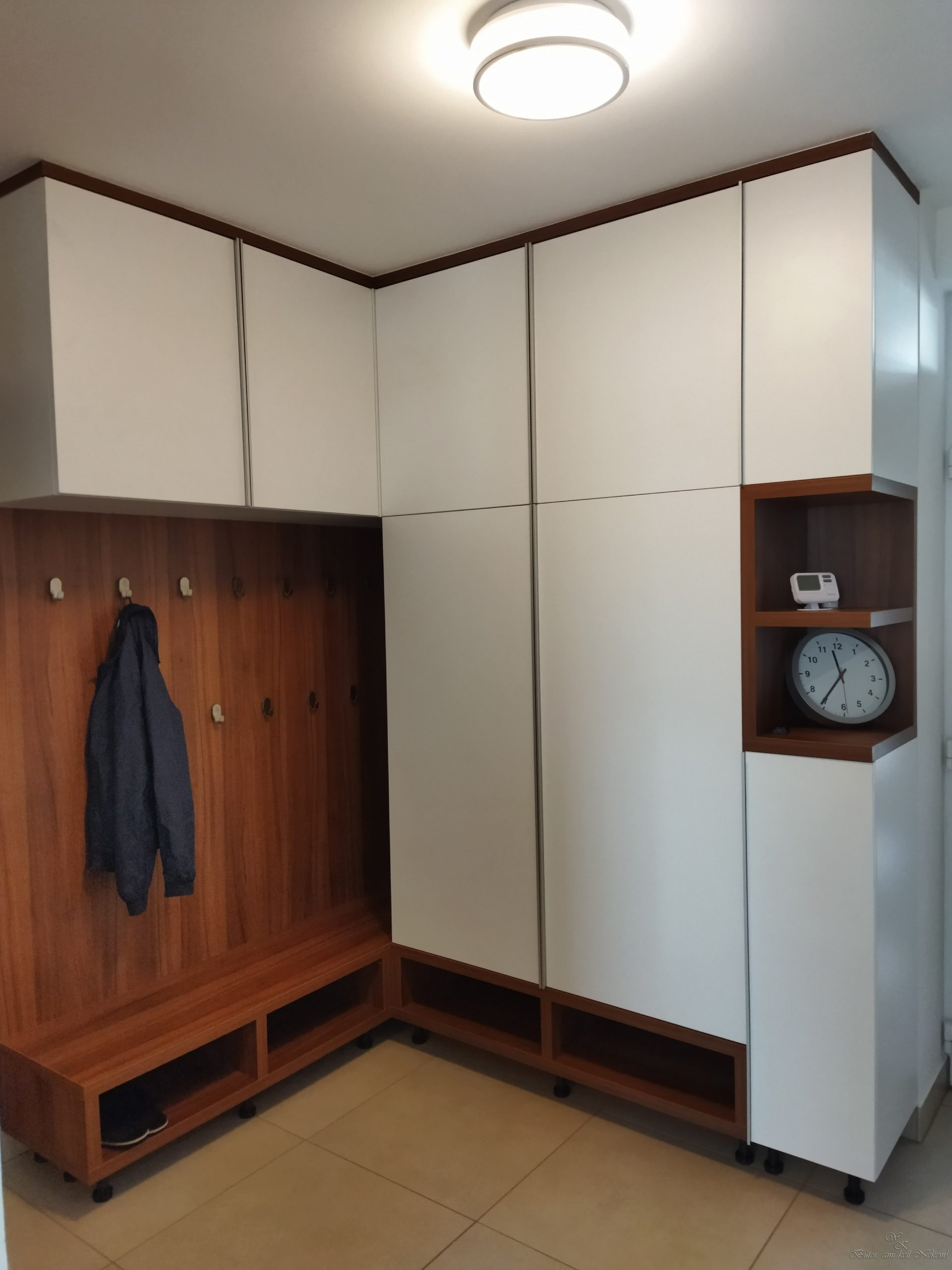 White and dark wood corner entryway unit with coat hooks, cabinets, cubbies, shelves, and a round clock.
