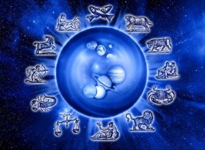 A luminous blue sphere appears at the center of a dark blue starry background. Small silver zodiac symbols form a ring around the sphere. Pale bubble-like circles and a curled abstract form sit inside the central orb.