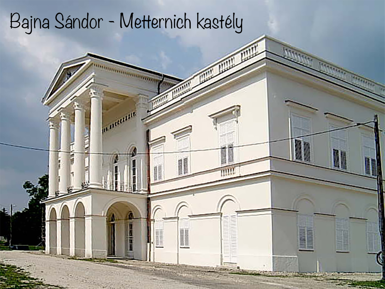 Classical white Sándor–Metternich Castle in Bajna with columns and shuttered windows.