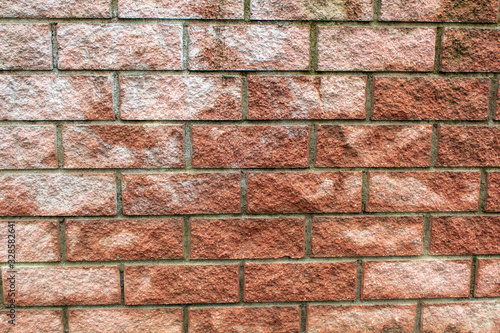 Close-up of weathered red and brown brickwork with dark mortar joints.