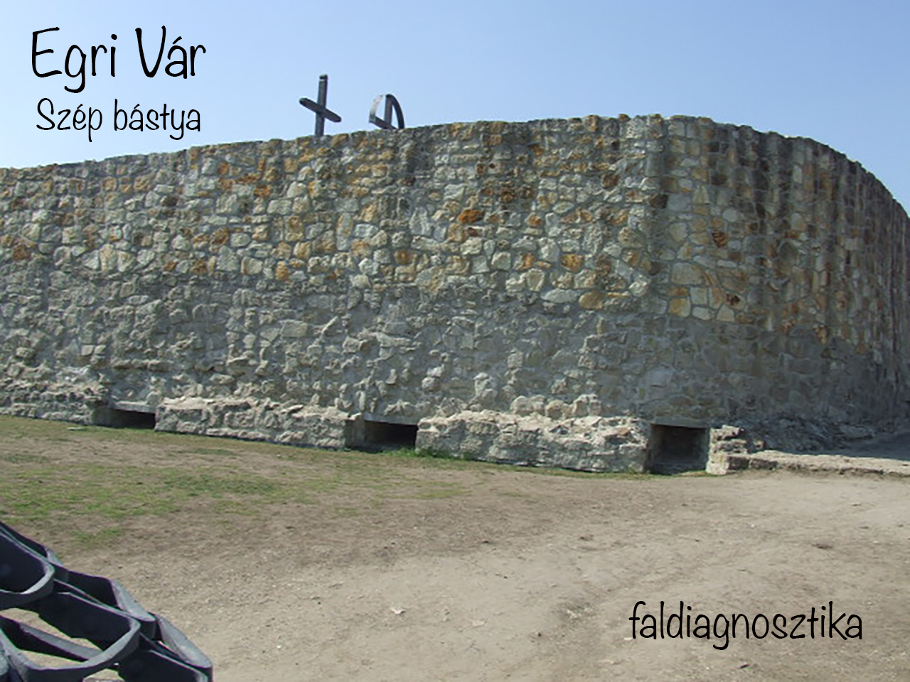 Rough stone wall of Eger Castle's Szép bastion with low openings.