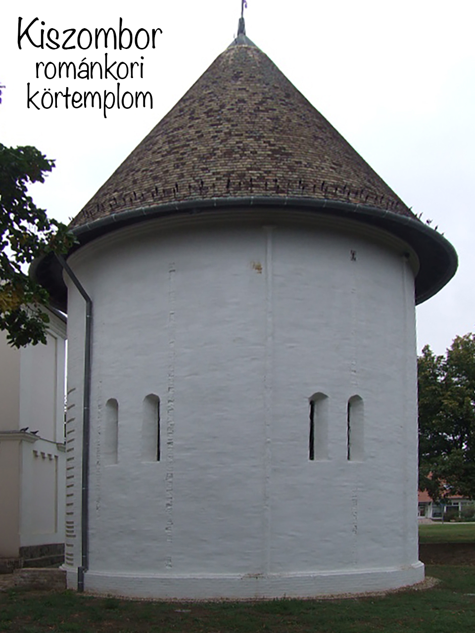 Rounded white apse and conical roof of the Kiszombor Romanesque rotunda church.