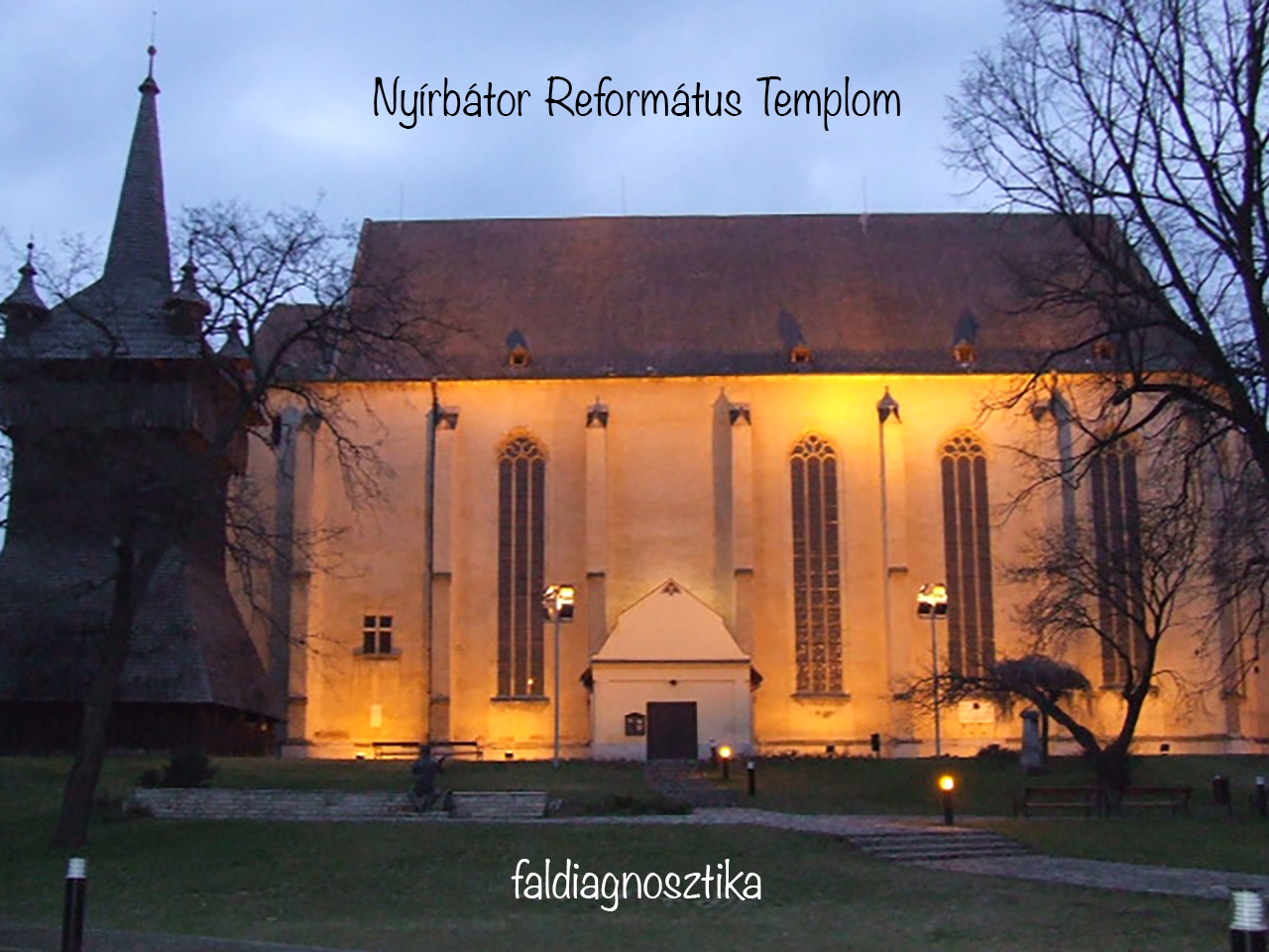 Warmly illuminated Nyírbátor Reformed Church at dusk.