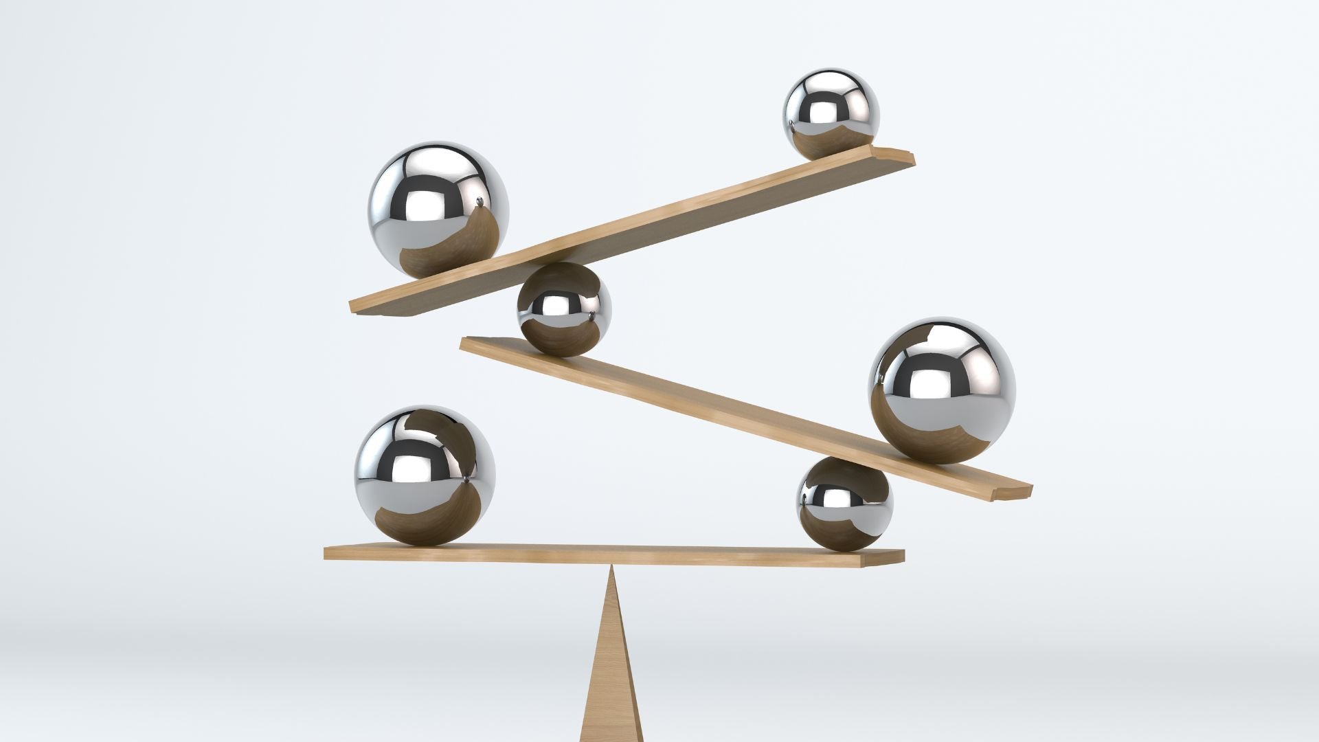 Six reflective metal spheres rest on three narrow wooden planks arranged as separate balance beams against a plain white background. The upper two planks slope upward to the right, while the lowest plank sits nearly level on a central support. The minimal image contains only the spheres and planks, with no text.