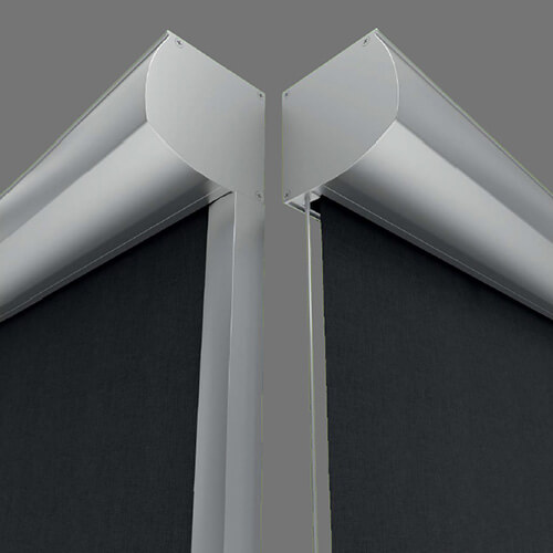 Two silver-colored frame sections meet near the upper center of the image. Dark charcoal fabric or mesh panels fill the lower area behind the frames. The paired metal pieces form angular end shapes, and a narrow vertical line descends between them.