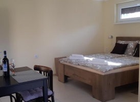 Hálószoba megvetett ággyal és a sarokban étkezőasztallal.