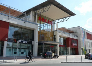 Exterior of a modern ÁRKÁD shopping center with a glass entrance.