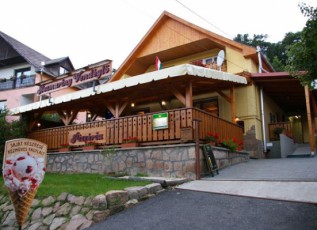 Timber-clad hospitality building with a covered balcony and ice-cream cone sign.