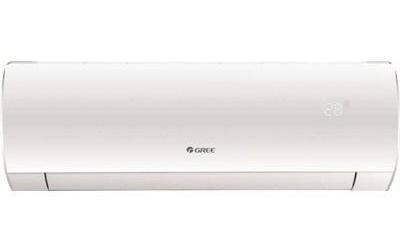A white wall-mounted split air-conditioning unit is shown straight-on against a white background. It has a long rectangular casing with rounded ends and a thin outlet seam along the lower edge; small “GREE” lettering appears near the center. A faint pale marking near the right side is too small to read.