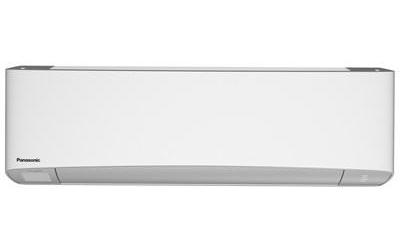 A white Panasonic indoor air-conditioning unit is shown from the front against a white background. Its casing has rounded corners, a light gray curved lower panel, and a narrow outlet seam along the bottom; the word “Panasonic” appears small at the lower left. No room or installation context is visible.