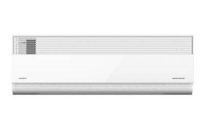 A long white wall-mounted air-conditioning unit is shown straight on against a pale background. A narrow band of horizontal grille slats runs across much of its upper area, with a darker mesh-like section near the left end. The lower front is mostly smooth, with a perforated strip along the bottom. Small markings appear near both ends but are not legible at this scale.