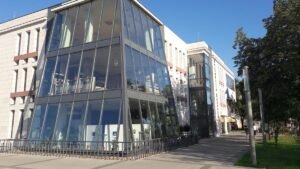 Üvegezett modern épület füves előtérrel