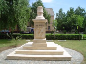 Kőből készült talapzatos emlékmű parkban.