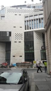 Modern, világos homlokzatú városi épület.