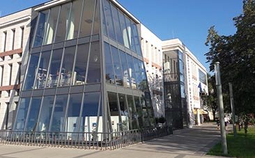 Üvegfalú modern épület világos oldalfalakkal.