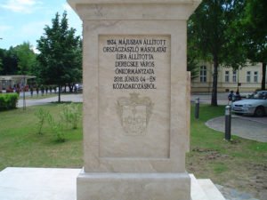 Feliratos kőemlékmű parkos környezetben.