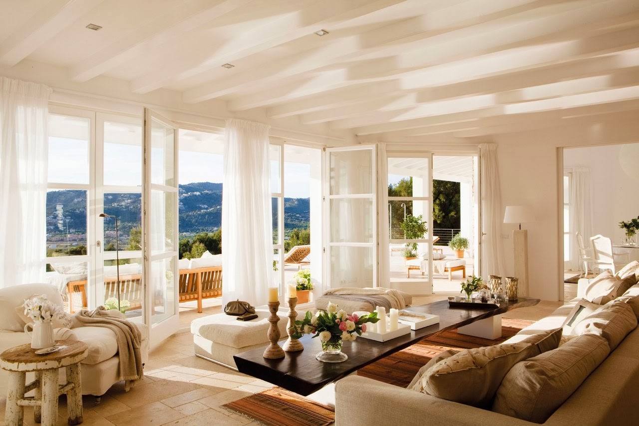 Bright white living room with open windows, sheer curtains, and mountain views.