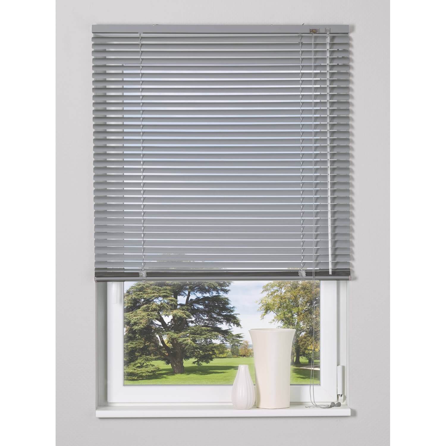 Grey Venetian blind over a window with a garden view.