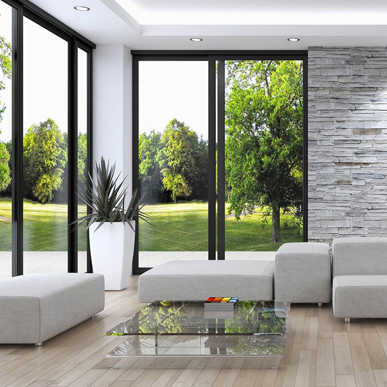 Modern living room with black-framed floor-to-ceiling windows and garden views.