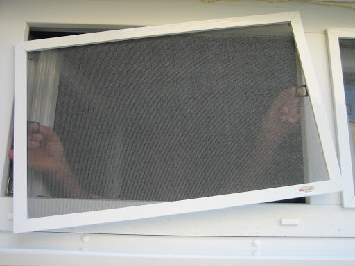 Open white-framed insect screen panel at a window.