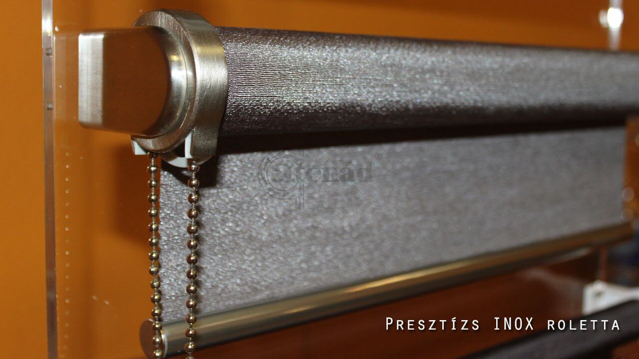 Close-up of a roller blind with metal hardware and beaded chains.