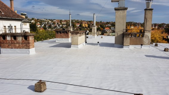 Flat roof waterproofing work viewed from above.