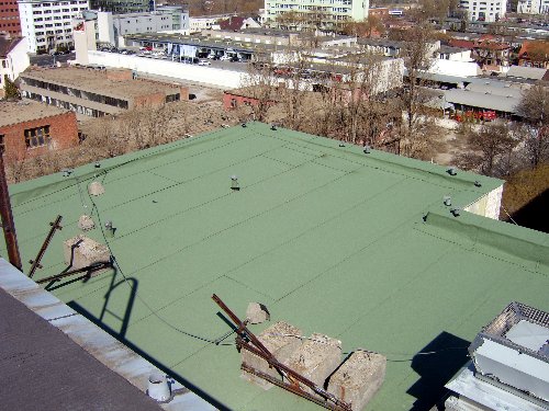 Flat roof waterproofing work viewed from above.