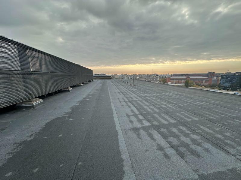 Flat roof waterproofing work viewed from above.