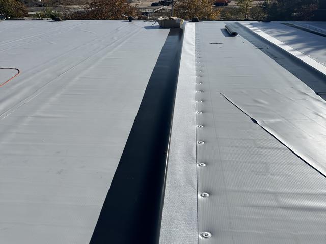 Flat roof waterproofing work viewed from above.