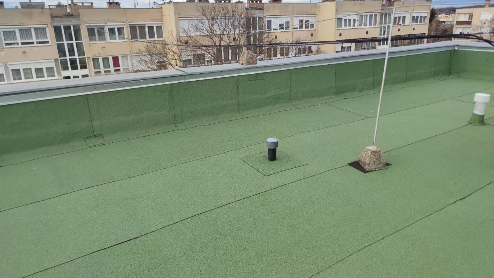 Flat roof waterproofing work viewed from above.