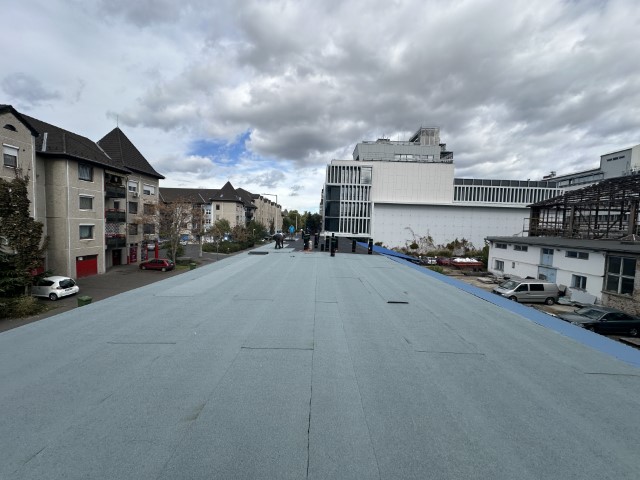 Flat roof waterproofing work viewed from above.