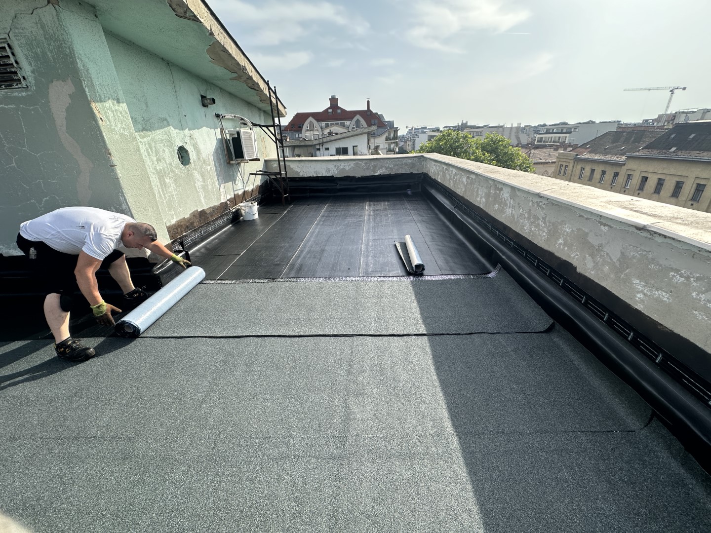 Flat roof waterproofing work viewed from above.