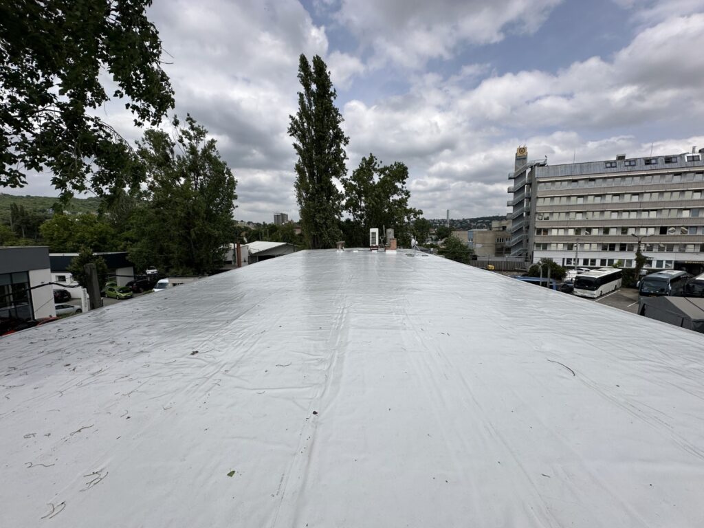 Flat roof waterproofing work viewed from above.