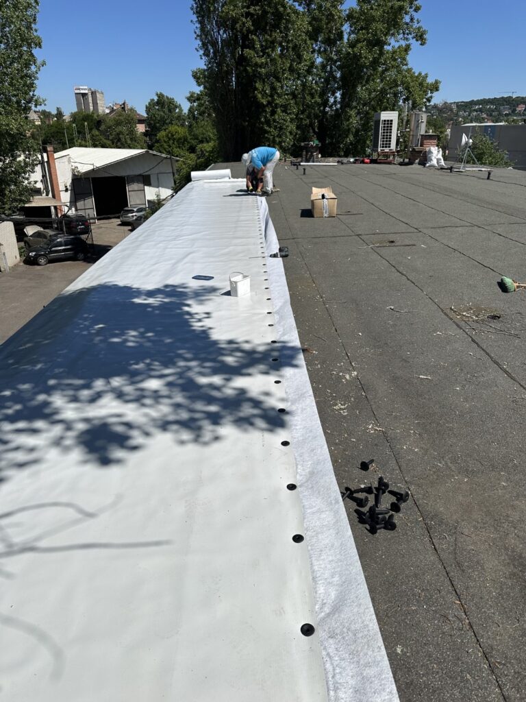 Flat roof waterproofing work viewed from above.