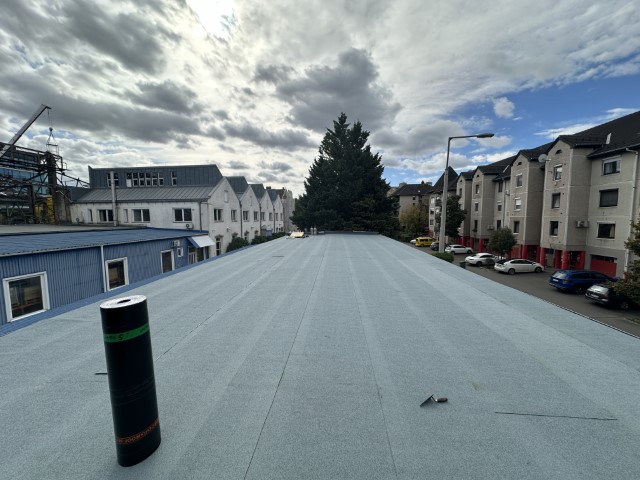Flat roof waterproofing work viewed from above.