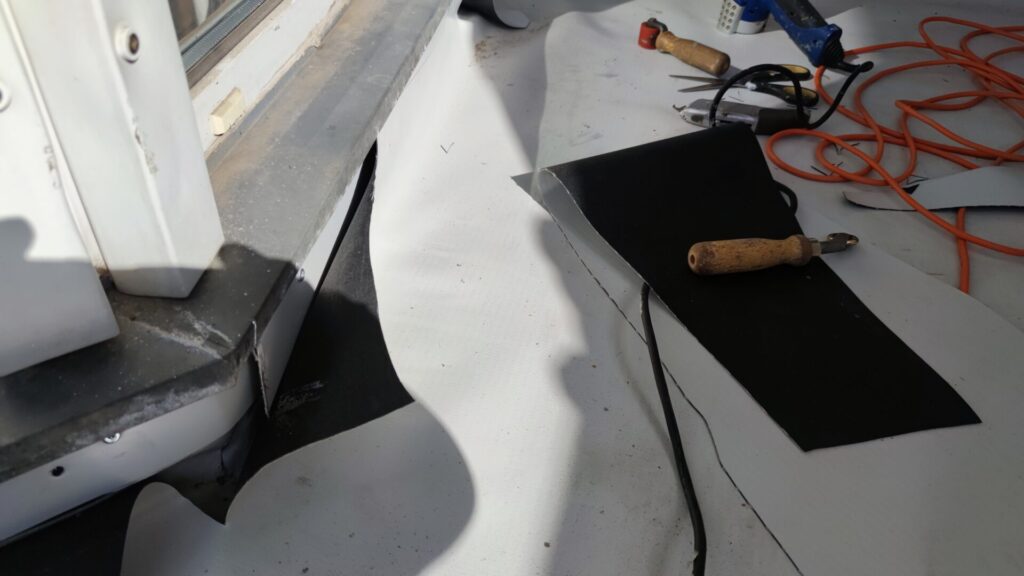 Flat roof waterproofing work viewed from above.