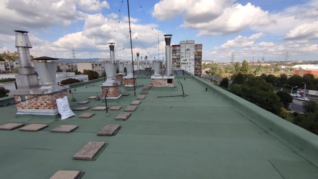 Flat roof waterproofing work viewed from above.