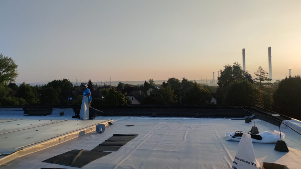 Flat roof waterproofing work viewed from above.