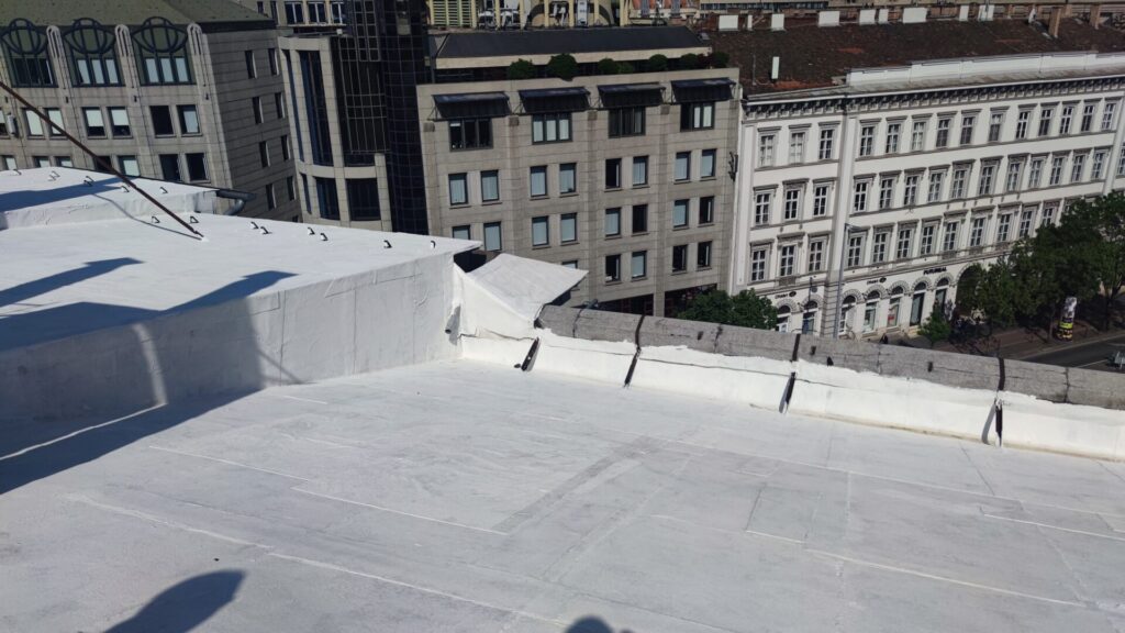 Flat roof waterproofing work viewed from above.