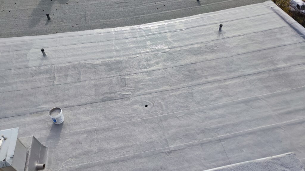 Flat roof waterproofing work viewed from above.