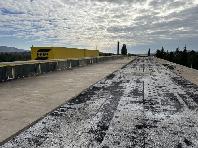 Flat roof waterproofing work viewed from above.
