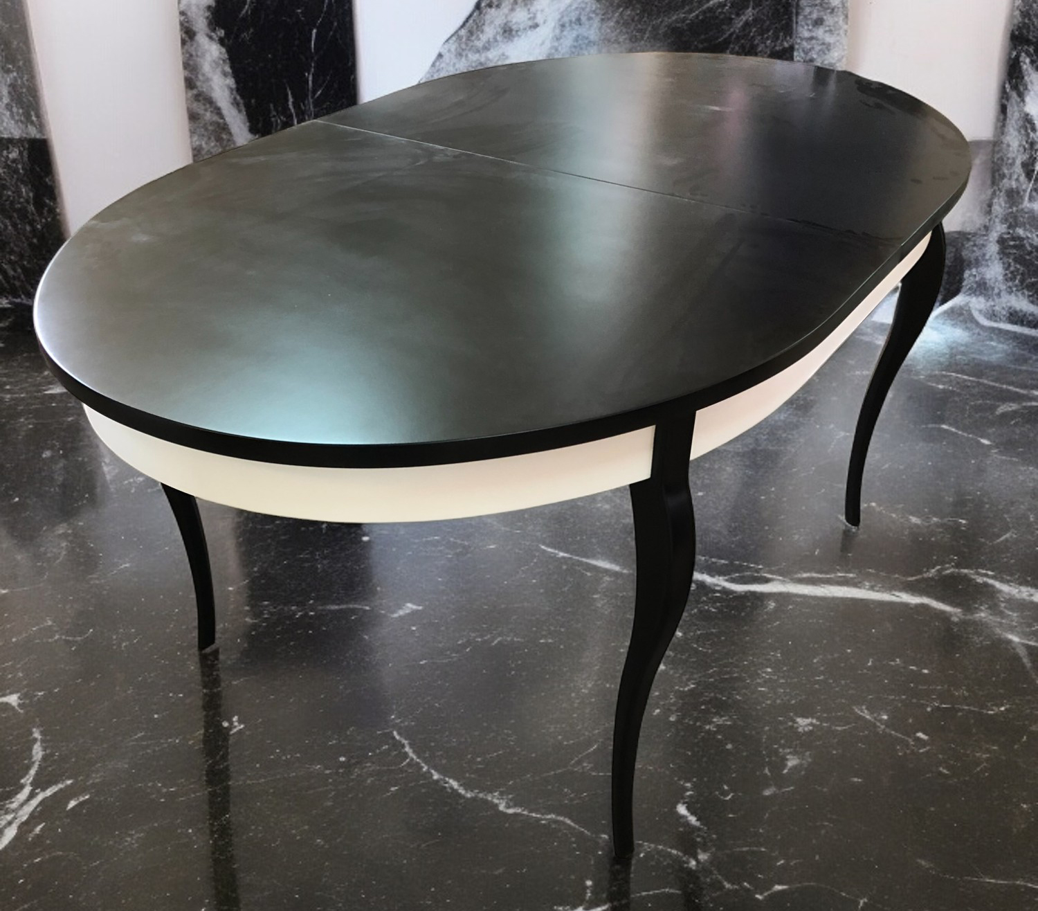 Black oval tabletop with white edge and central pedestal base.
