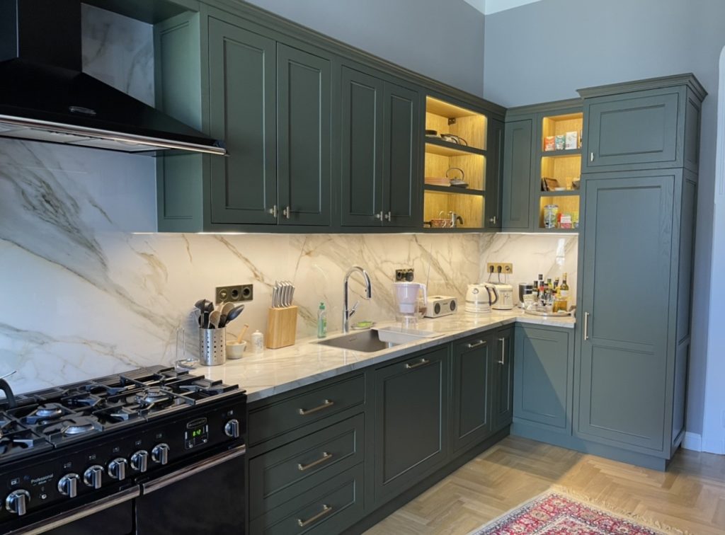 Blue-gray kitchen with island and range.