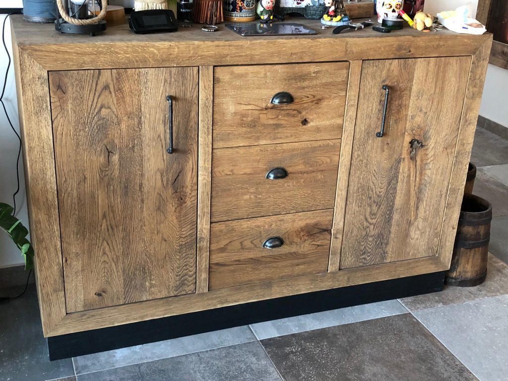 Dark wood sideboard with drawers and inset chevron-like door fronts.