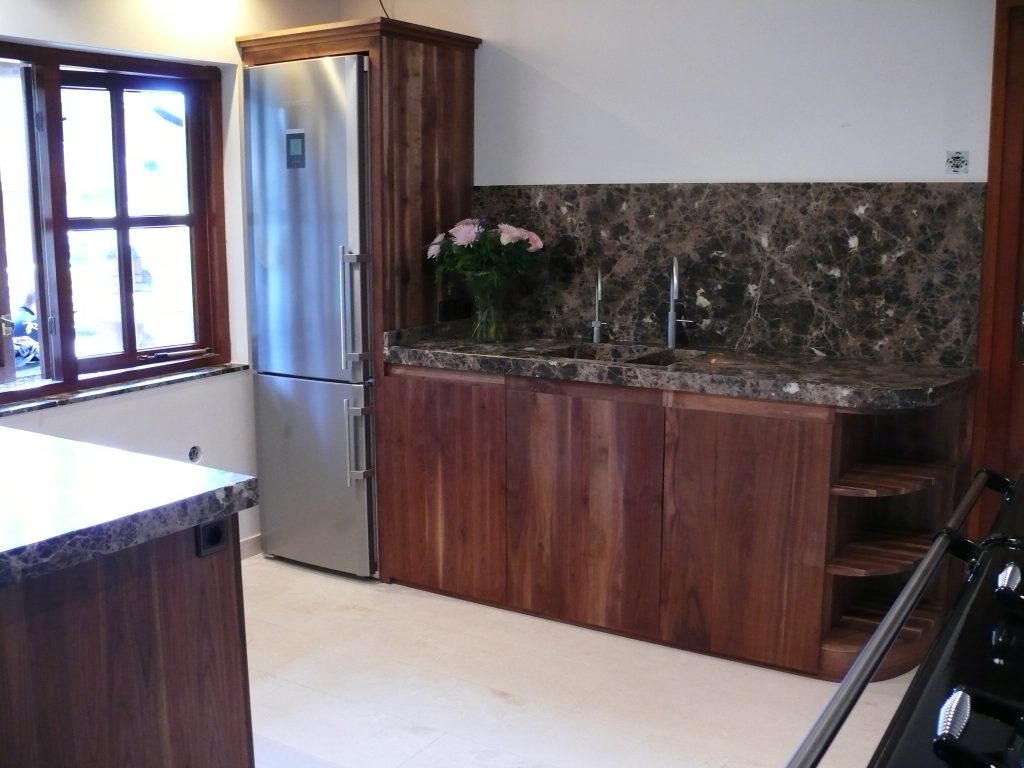 Dark wood sideboard or kitchen run beneath a marbled wall panel.