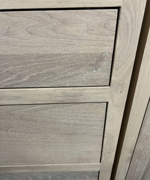 Diagonal join of pale cabinet fronts.