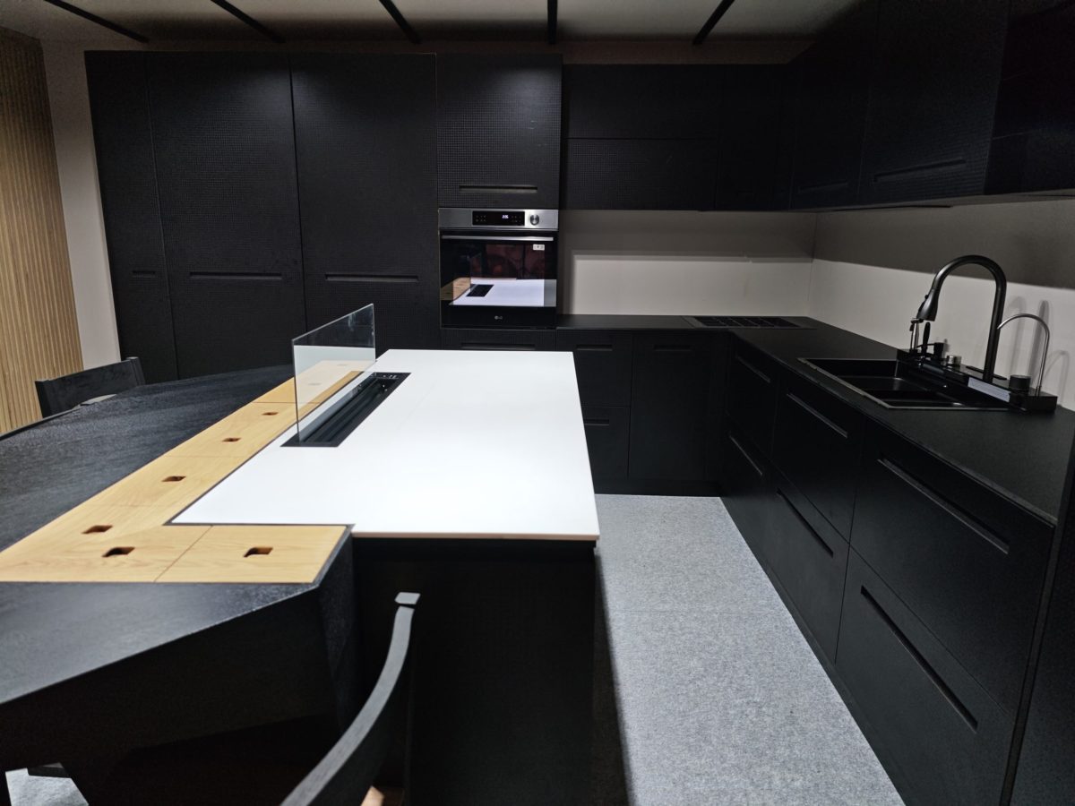 Black kitchen run with white counter, sink and wood side panels.
