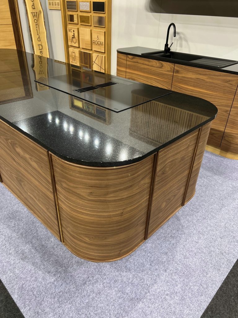 Close angled view of wood island with curved drawer fronts.